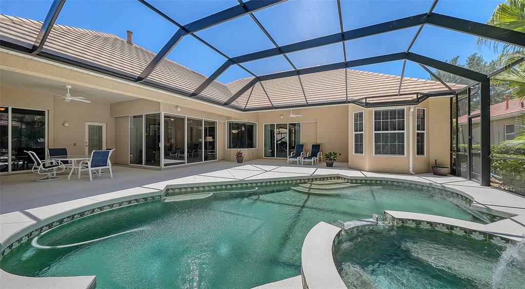 A screened-in patio features a swimming pool, a hot tub, and outdoor seating — 7507 ABBEY GLEN, BRADENTON, FL