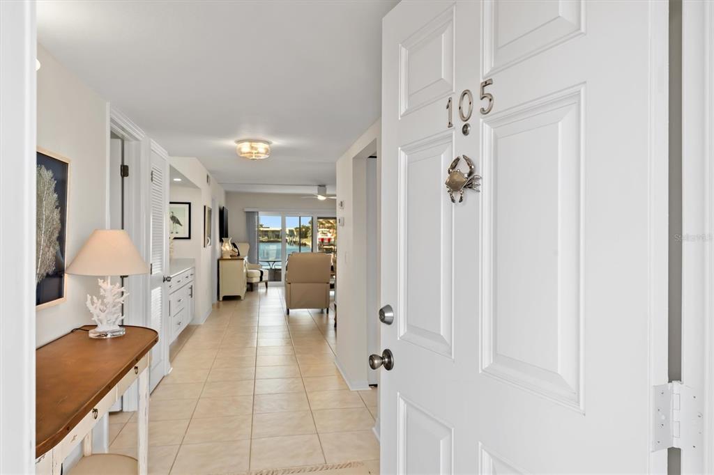 A view from an open front door into a tiled hallway leading to a living area — 1345 MEDITERRANEAN DRIVE UNIT A105, PUNTA GORDA, FL