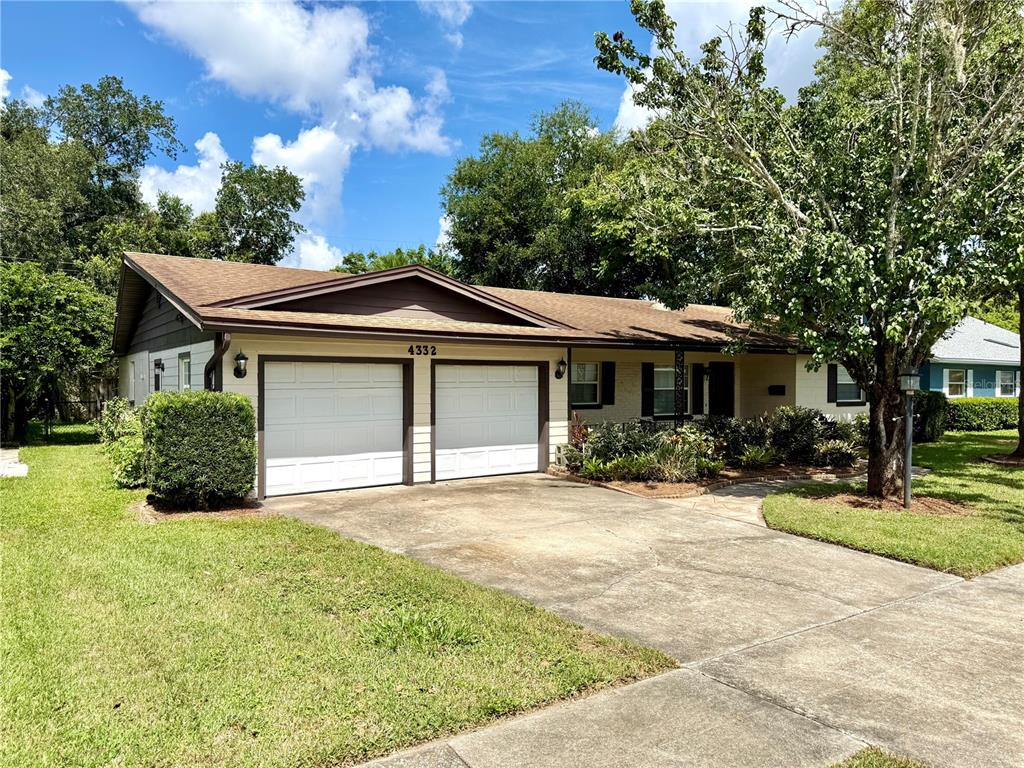 A single-story house features a two-car garage, a concrete driveway, and a landscaped front yard — 4332 BLONIGEN AVENUE, ORLANDO, FL