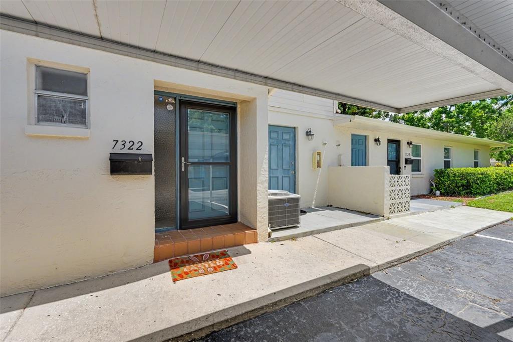 The exterior of a single-story residential unit features a covered walkway and a front door — 7322 STONE HAVEN COURT N UNIT 7322, PINELLAS PARK, FL