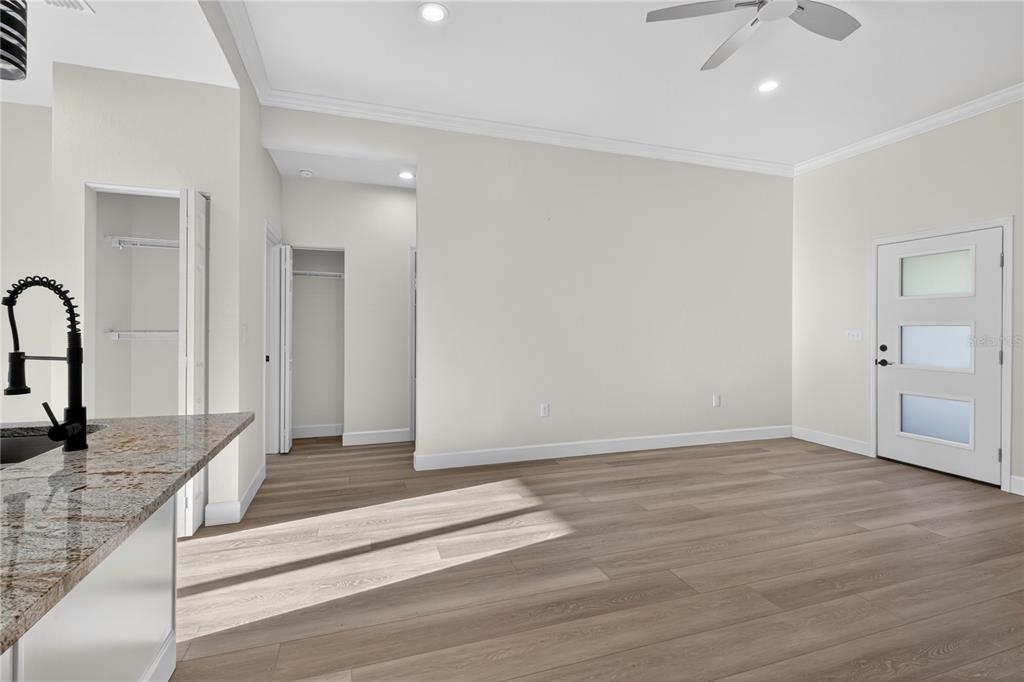 A kitchen island with a granite countertop overlooks a living area with light wood flooring — 661 NE 150TH COURT, WILLISTON, FL