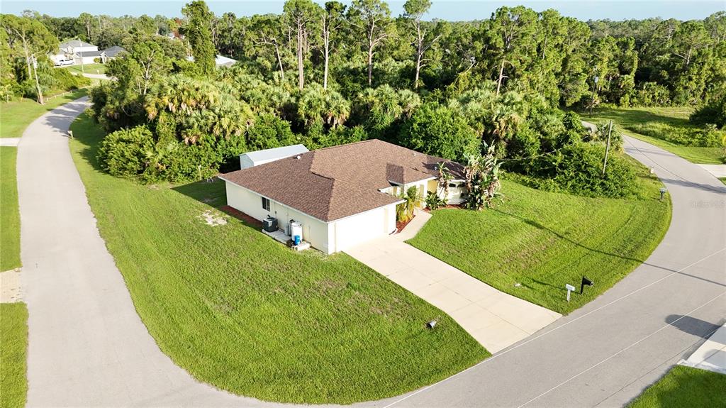 An aerial view of a single-story house with a brown roof and a concrete driveway — 2991 GRANDVIEW DRIVE, NORTH PORT, FL