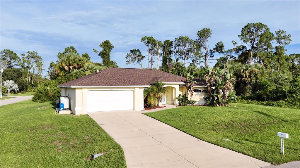 A single-story house with a white garage door, tan stucco walls, and a brown roof — 2991 GRANDVIEW DRIVE, NORTH PORT, FL