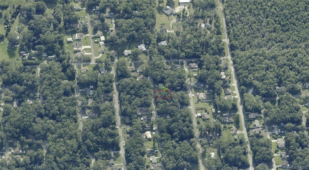 An aerial view shows a wooded residential lot outlined in red with a green marker — 5975 E CALICO LANE, INVERNESS, FL