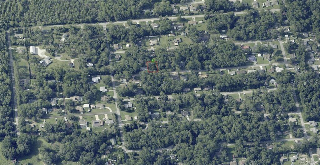 An aerial view shows a wooded residential neighborhood with a highlighted vacant lot — 5975 E CALICO LANE, INVERNESS, FL