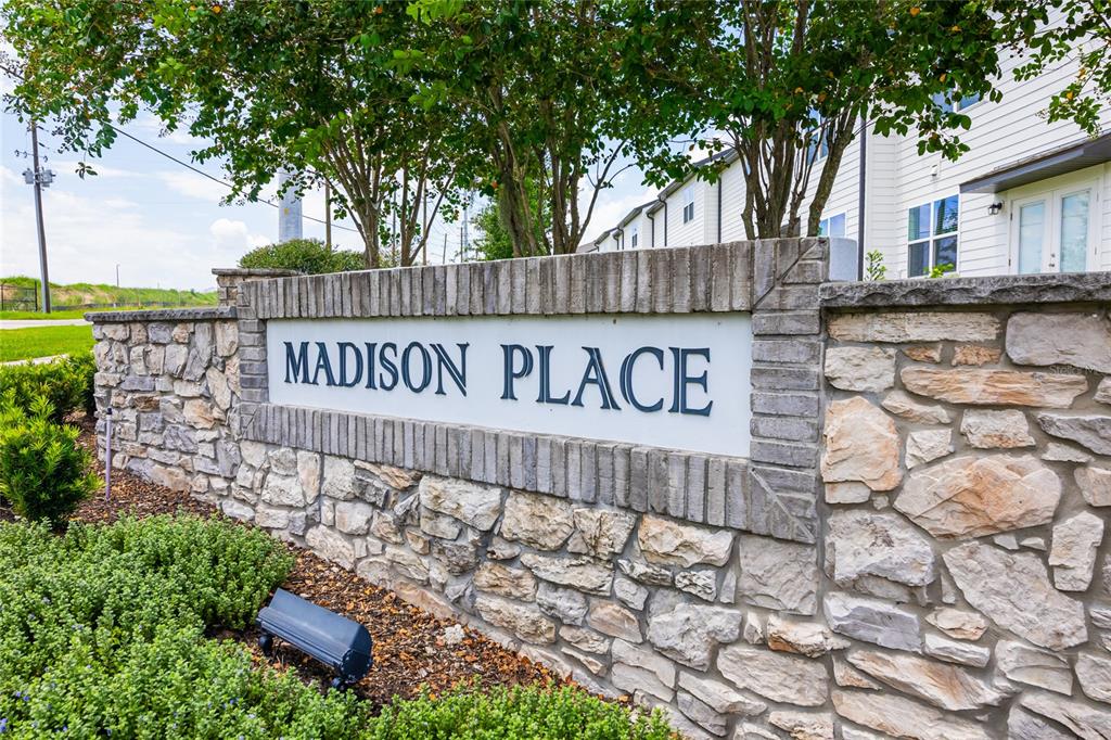 A stone monument sign with the words Madison Place stands in front of a building — 529 MADISON DRIVE, DAVENPORT, FL