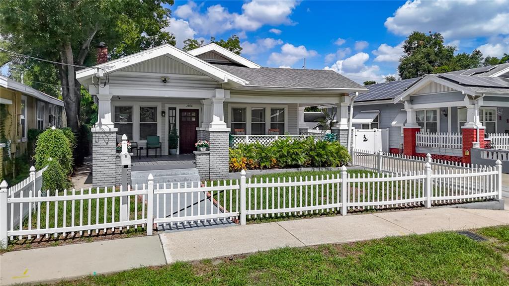 A single-story house with a front porch and white picket fence under a blue sky — 3506 N 12TH STREET, TAMPA, FL