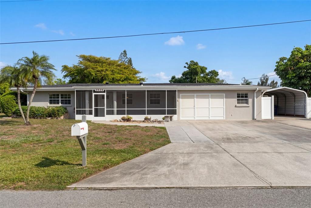 A single-story house with a screened front porch, a two-car garage, and a carport — 5929 MURDOCK AVENUE, SARASOTA, FL