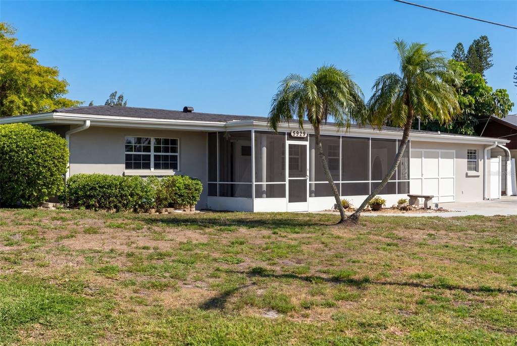 A single-story house with a screened-in front porch and two palm trees in the yard — 5929 MURDOCK AVENUE, SARASOTA, FL