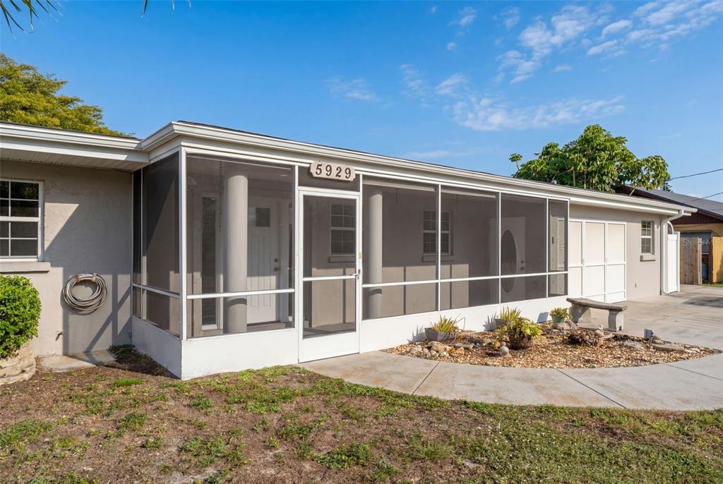 A single-story house features a screened-in front porch and a concrete walkway — 5929 MURDOCK AVENUE, SARASOTA, FL