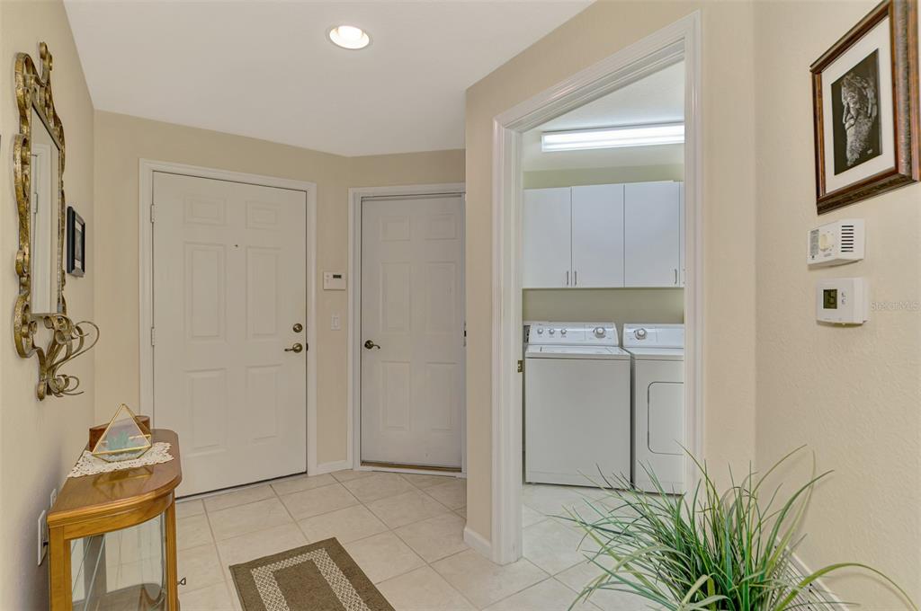 An entryway with tile flooring leads to a laundry room containing a washer and dryer — 3433 GRAND VISTA COURT UNIT 102, PORT CHARLOTTE, FL