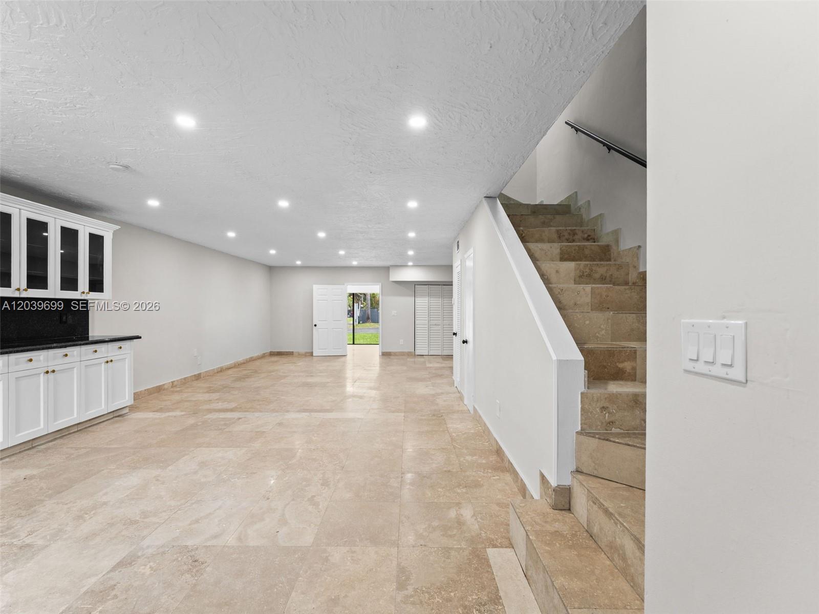 A room with tile flooring, white cabinets, and a staircase leading to an upper level — 13502 NE 24th Ct, North Miami FL 33181, NORTH MIAMI, FL