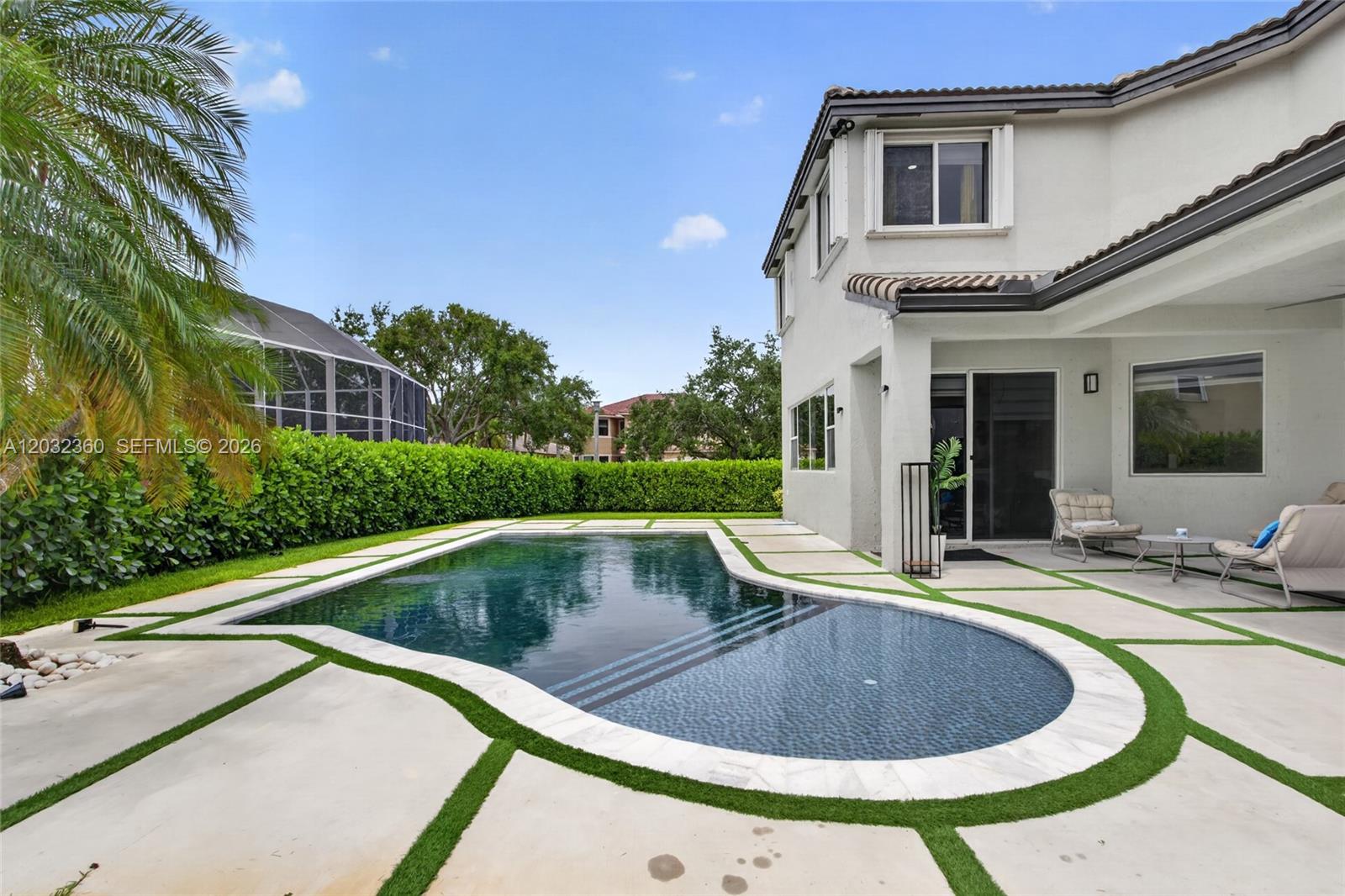 A backyard features a kidney-shaped swimming pool surrounded by concrete pavers with artificial grass joints — 2167 SW 176th Ter, Miramar FL 33029, MIRAMAR, FL