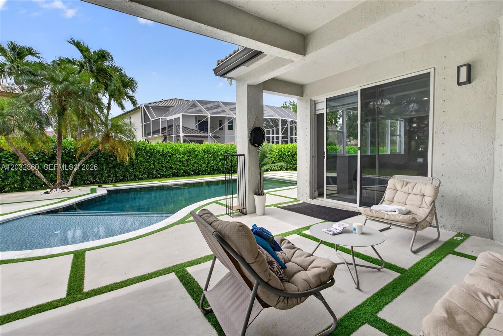 A covered patio features concrete pavers with artificial turf, two lounge chairs, and a pool — 2167 SW 176th Ter, Miramar FL 33029, MIRAMAR, FL
