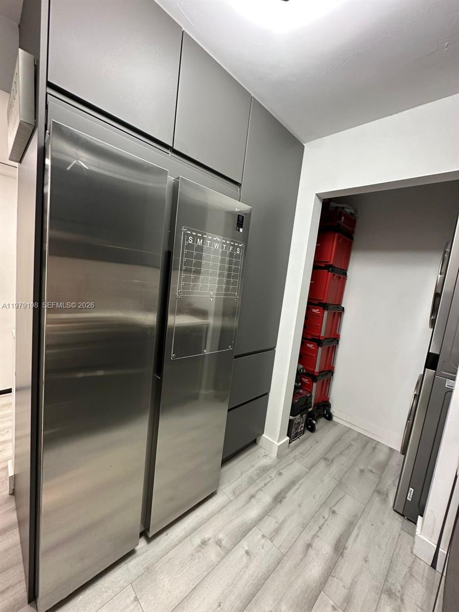 A modern kitchen features stainless steel appliances, dark gray cabinetry, and light wood-look flooring — 931 NE 199th St # 22, Miami FL 33179, MIAMI, FL