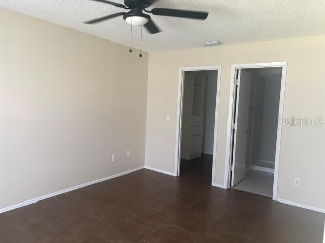 A white washer and dryer sit inside an outdoor utility closet with a storage shelf — 208 NORTHLAKE DRIVE UNIT 208, SANFORD, FL