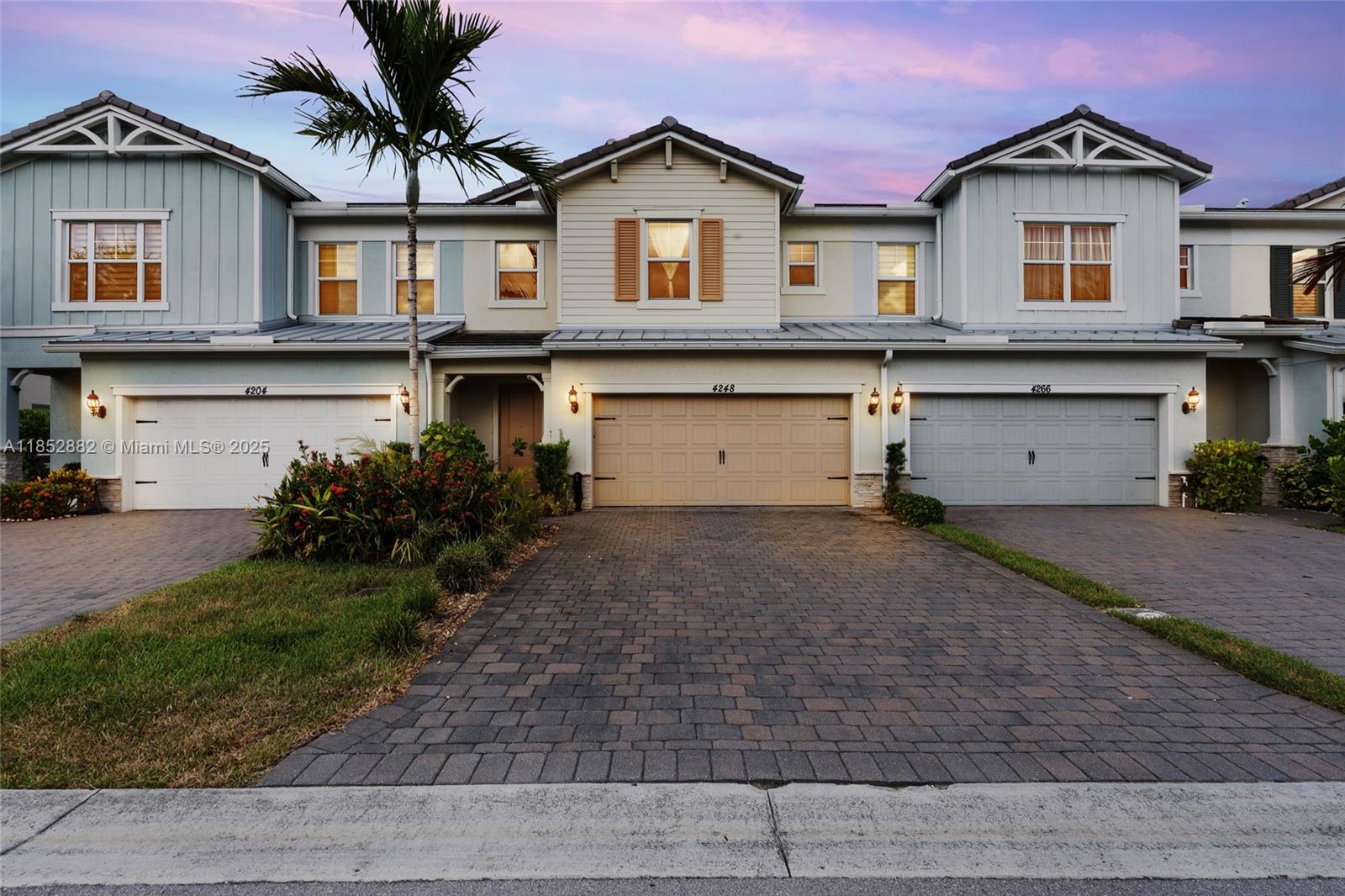 A row of three two-story townhouses features paved driveways, attached garages, and light-colored siding — 4248 Ficus St, Hollywood FL 33021, HOLLYWOOD, FL