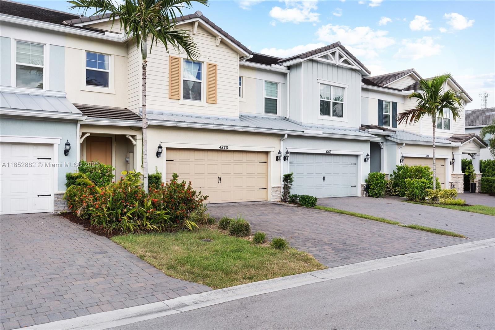 A row of multi-story townhouses features attached garages, paved driveways, and small front gardens — 4248 Ficus St, Hollywood FL 33021, HOLLYWOOD, FL