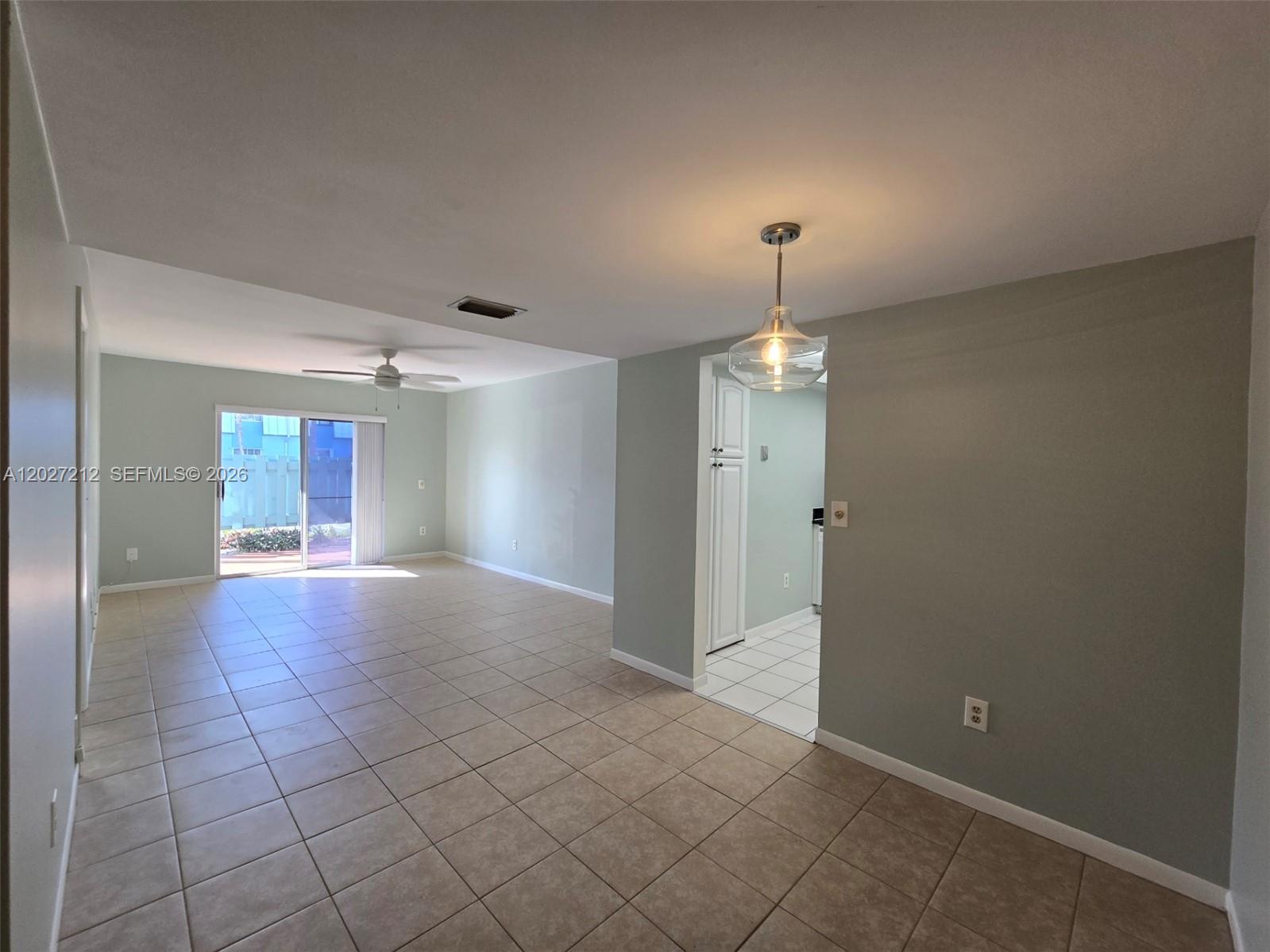 An open-concept living and dining area features light green walls and beige tile flooring — 950 S Kanner Hwy # 4, Stuart FL 34994, STUART, FL