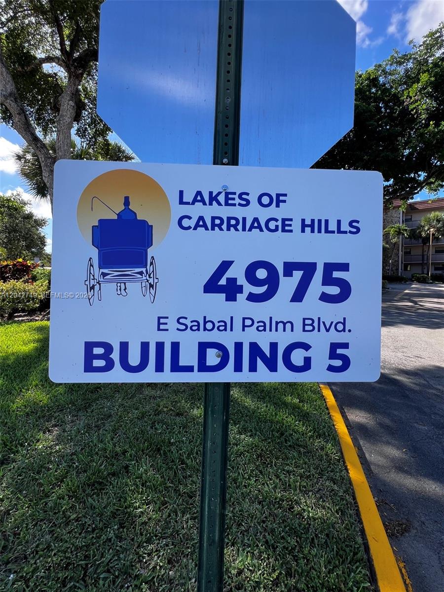 A sign for Lakes of Carriage Hills stands on a pole in a grassy area — 4975 E Sabal Palm Blvd # 304, Tamarac FL 33319, TAMARAC, FL