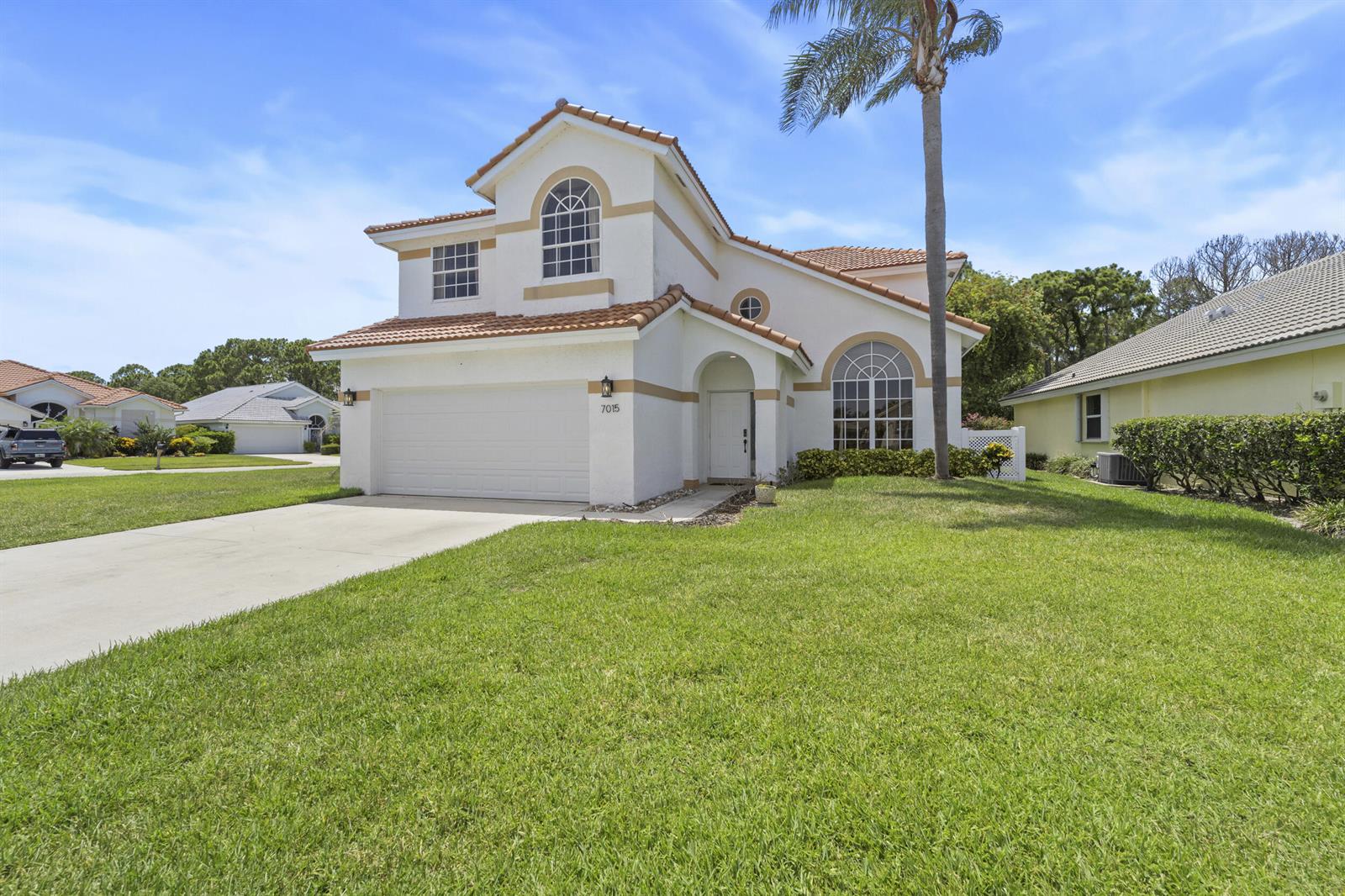 A two-story house with a white stucco exterior, tile roof, and a two-car garage — 7015 SE Cutler Trail SE, Stuart FL 34997, STUART, FL