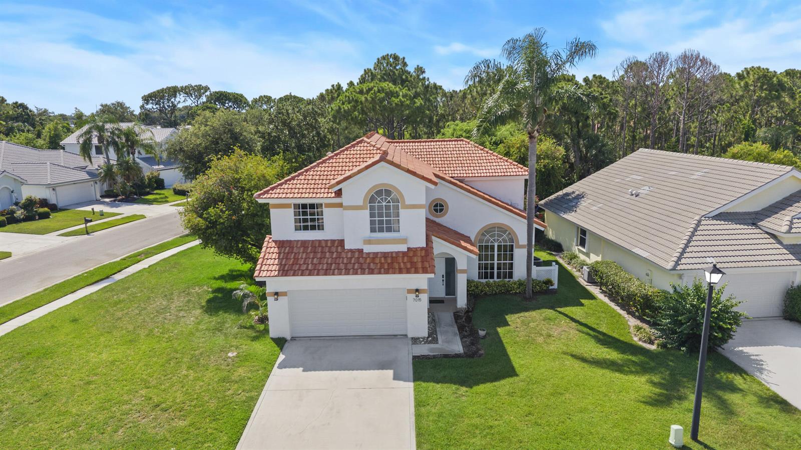 An aerial view of a two-story house with a tile roof and a concrete driveway — 7015 SE Cutler Trail SE, Stuart FL 34997, STUART, FL