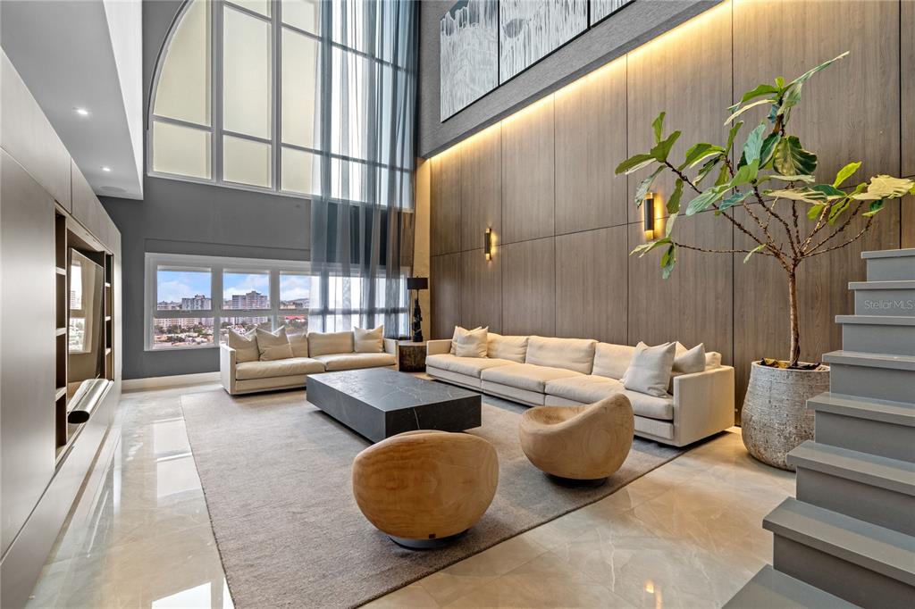 A modern living room features a double-height ceiling, wood-paneled walls, and a large sectional sofa — 105 ORTEGON AVENUE UNIT PH1, GUAYNABO, PR
