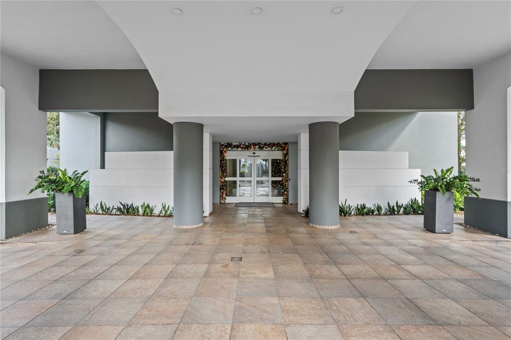 A covered building entrance features large gray columns, tiled flooring, and glass double doors — 105 ORTEGON AVENUE UNIT PH1, GUAYNABO, PR