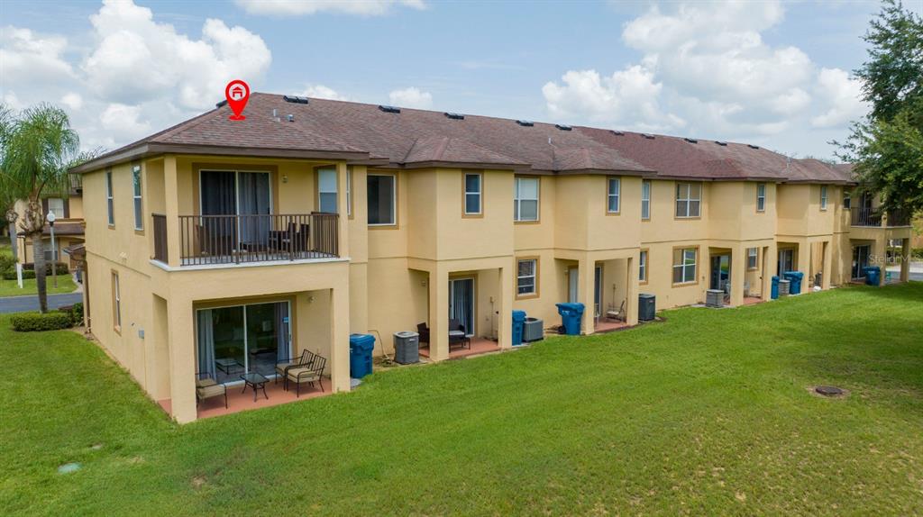 A multi-story apartment building with tan stucco walls, brown shingled roofs, and private balconies — 206 BERGAMO DRIVE, DAVENPORT, FL
