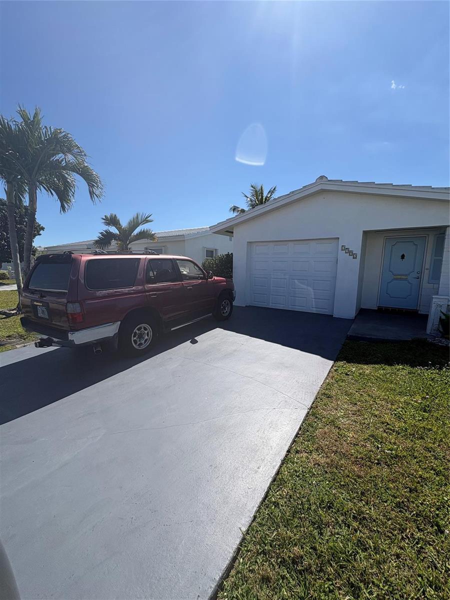 A red SUV is parked in the driveway of a white house with a garage — 2392 SW 13th Terrace, Boynton Beach FL 33426, BOYNTON BEACH, FL