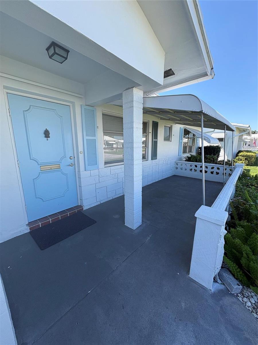 A light blue front door opens onto a covered concrete porch with a metal awning — 2392 SW 13th Terrace, Boynton Beach FL 33426, BOYNTON BEACH, FL
