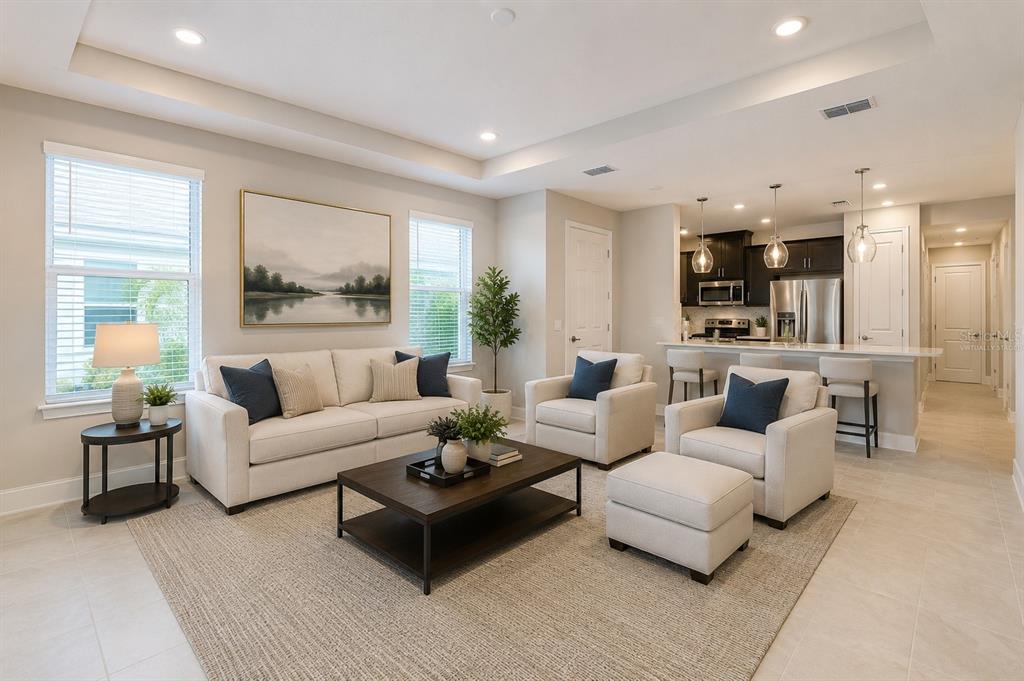 A living room with a sofa, two armchairs, and a coffee table faces an open kitchen — 6017 MESA GLEN, BRADENTON, FL