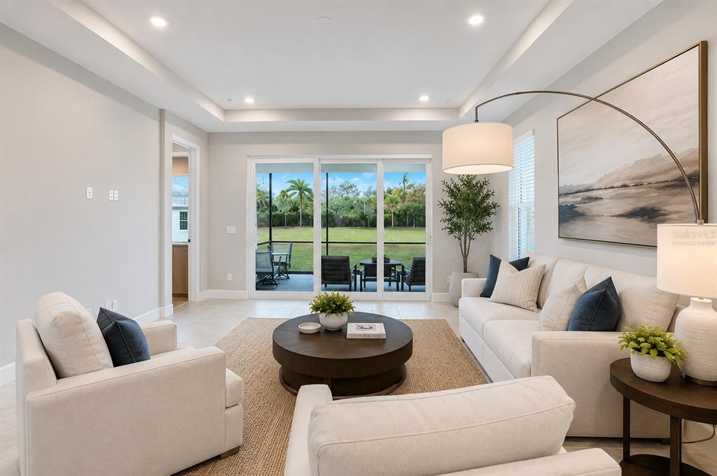 A living room features a sofa, two armchairs, a coffee table, and sliding glass doors — 6017 MESA GLEN, BRADENTON, FL