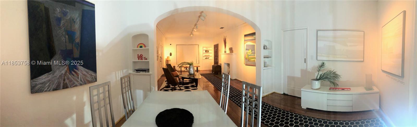 A dining area with a glass table leads through an archway into a living room — 1619 SW 13th St, Miami FL 33145, MIAMI, FL