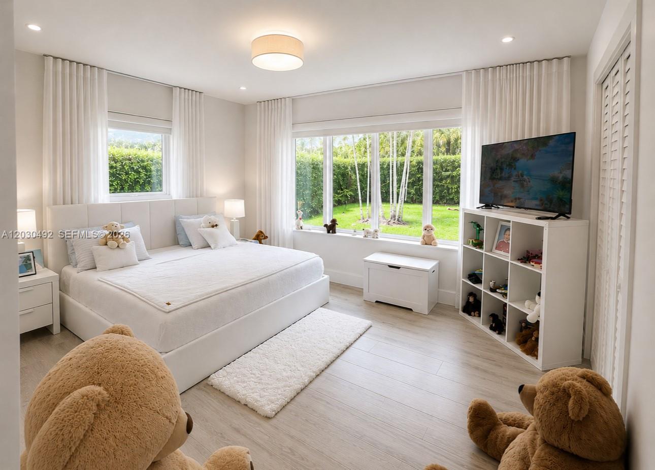 A bright bedroom features a white bed, large windows, a toy shelf, and teddy bears — 1905 Alamanda Dr, North Miami FL 33181, NORTH MIAMI, FL