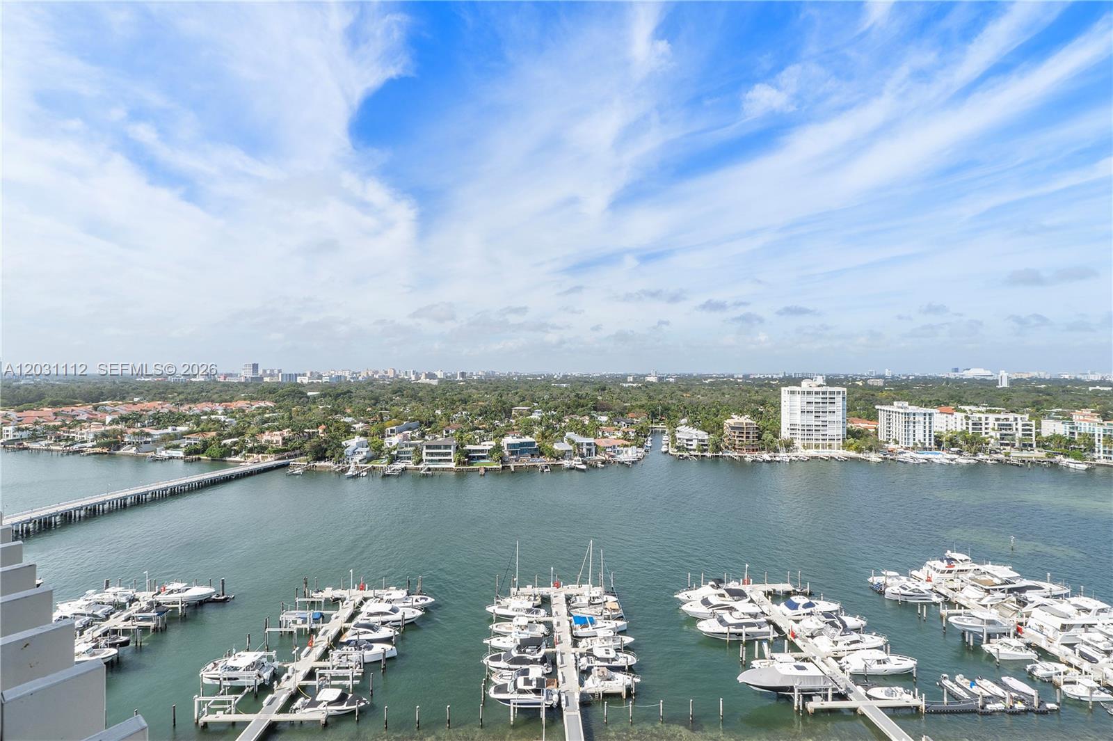 An elevated view shows a marina with numerous docked boats and a coastal residential area — 2 Grove Isle Dr, Miami FL 33133, MIAMI, FL