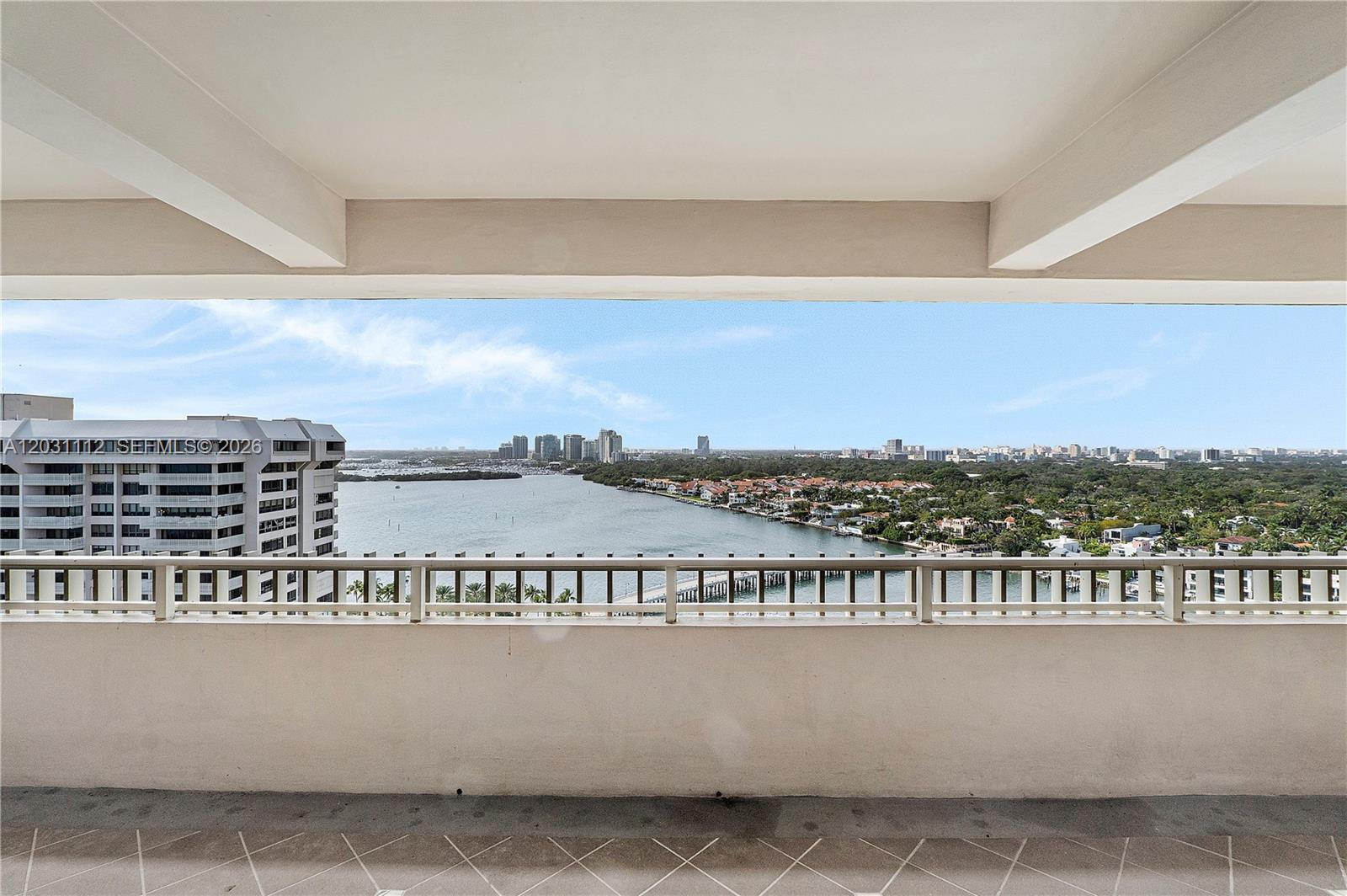 A balcony overlooks a wide waterway, a marina, and a distant city skyline — 2 Grove Isle Dr, Miami FL 33133, MIAMI, FL