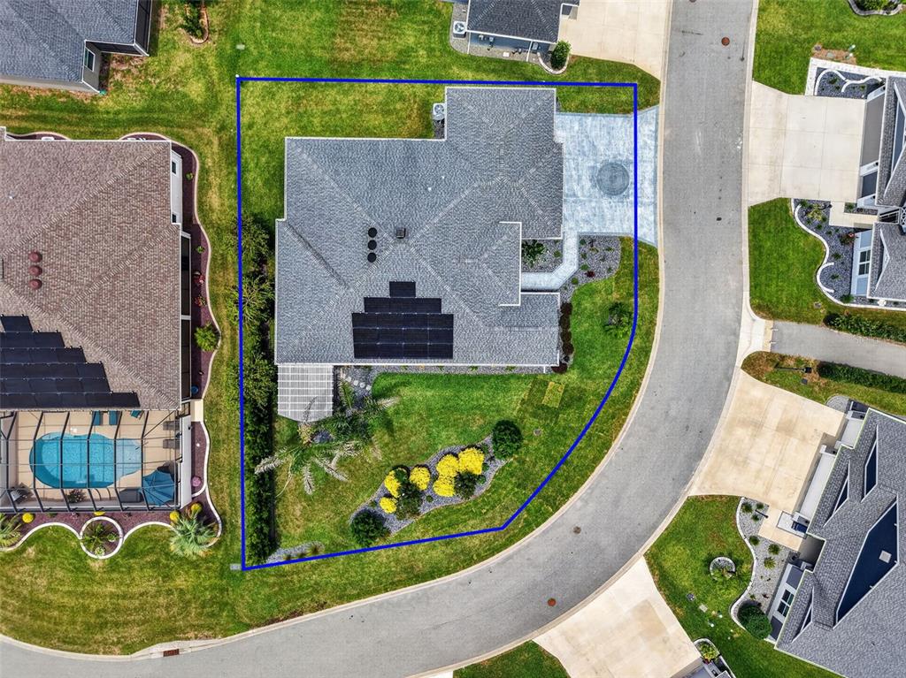 An aerial view shows a house with solar panels on a corner lot — 6328 MERHOTTEIN LOOP, THE VILLAGES, FL