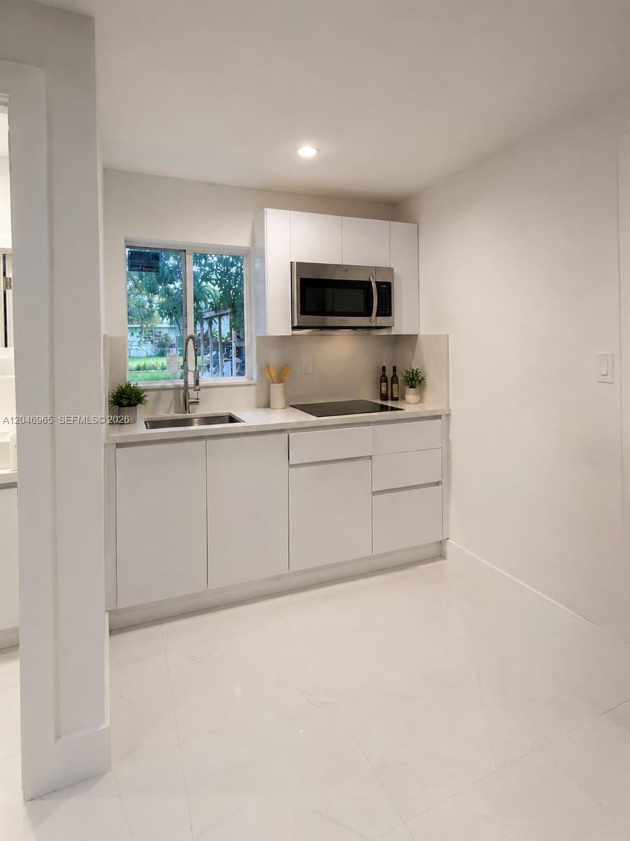 A bedroom features a neutral-toned bed, two nightstands, a dresser, and a wall-mounted air conditioner — 521 NW 33rd Ave # 1, Miami FL 33125, MIAMI, FL