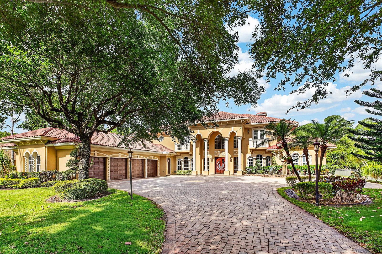 A large two-story Mediterranean-style house with a four-car garage and a paved circular driveway — 6071 NW 69th Way, Parkland FL 33067, PARKLAND, FL