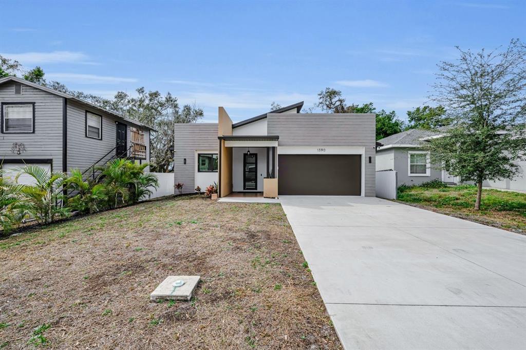 A modern single-story house with a brown garage door and a concrete driveway — 1590 S WASHINGTON AVENUE, CLEARWATER, FL