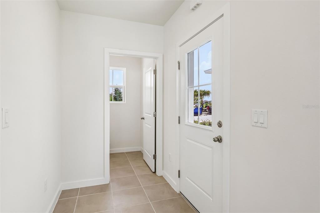 A tiled entryway features a white door with a window and an open interior doorway — 2692 MEADOW CREST DRIVE, ST CLOUD, FL