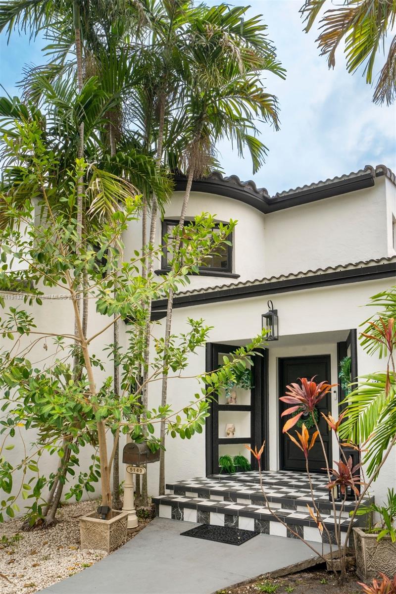 A white two-story house features a black-and-white checkered porch and a black front door — 5149 Alton Rd, Miami Beach FL 33140, MIAMI BEACH, FL
