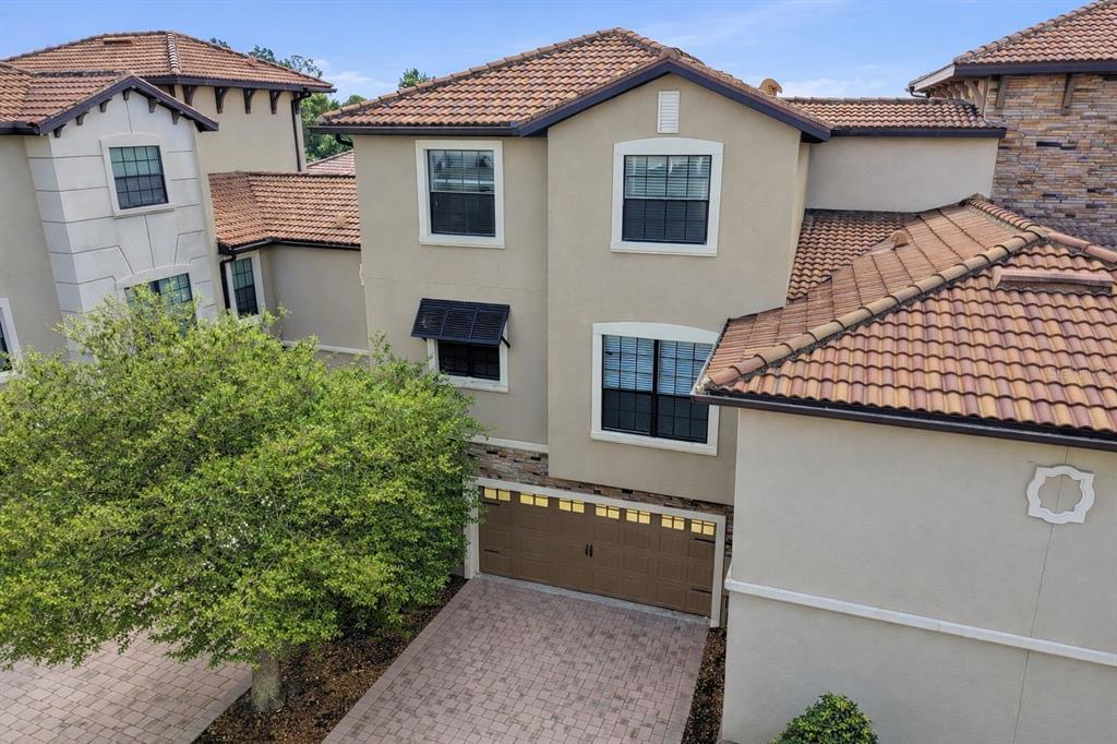 An exterior view of a two-story stucco house with a tile roof and garage — 1341 SHINNECOCK HILLS DRIVE, DAVENPORT, FL