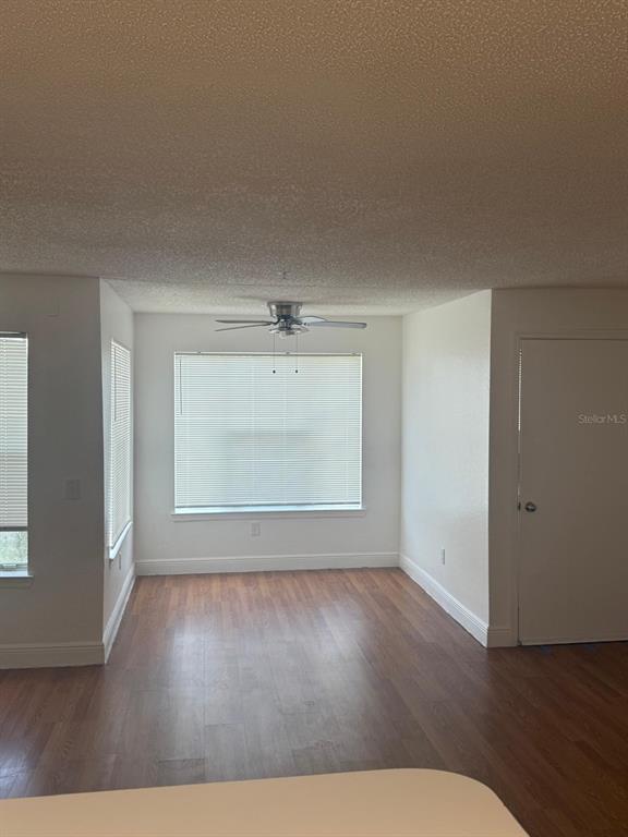 An empty room with wood-look flooring, a ceiling fan, and large windows with blinds — 2202 KEY WEST COURT UNIT 626, KISSIMMEE, FL