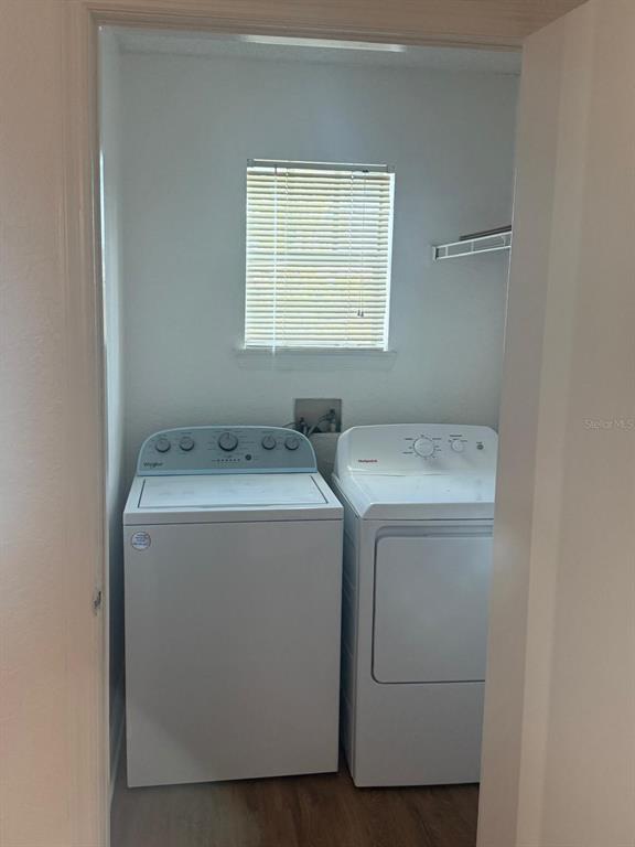 A laundry room features a white top-load washer and dryer beneath a window with blinds — 2202 KEY WEST COURT UNIT 626, KISSIMMEE, FL