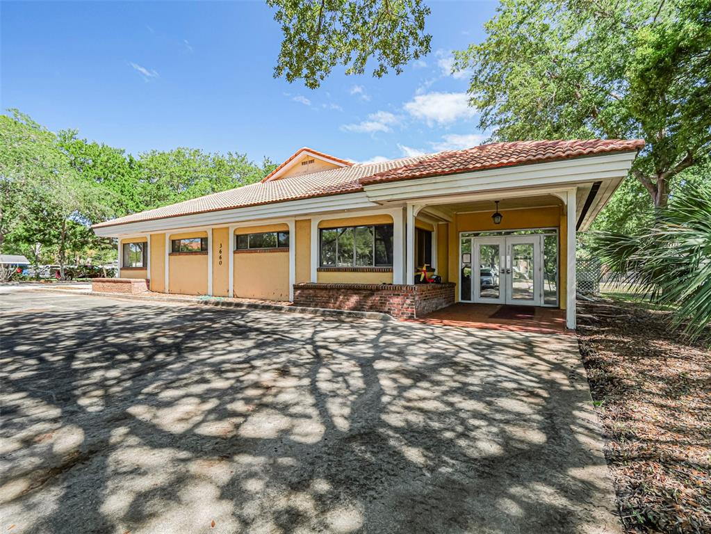 A single-story commercial building with a tiled roof, yellow stucco walls, and a covered entrance — 3660 20TH STREET, VERO BEACH, FL