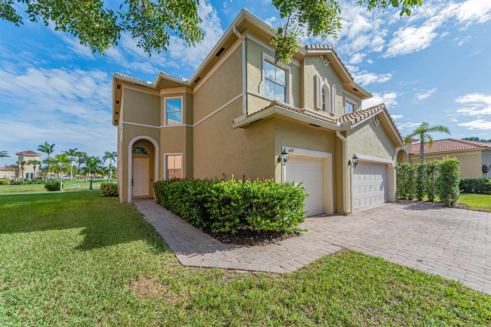 A two-story stucco house with a two-car garage and a paved walkway — 6027 Arlington Way, Fort Pierce FL 34951, FORT PIERCE, FL