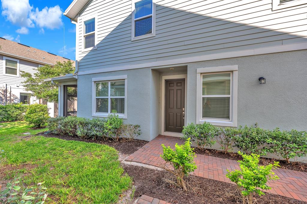 The exterior of a two-story house features light blue siding, a brick walkway, and a front door — 5741 SPOTTED HARRIER WAY, LITHIA, FL
