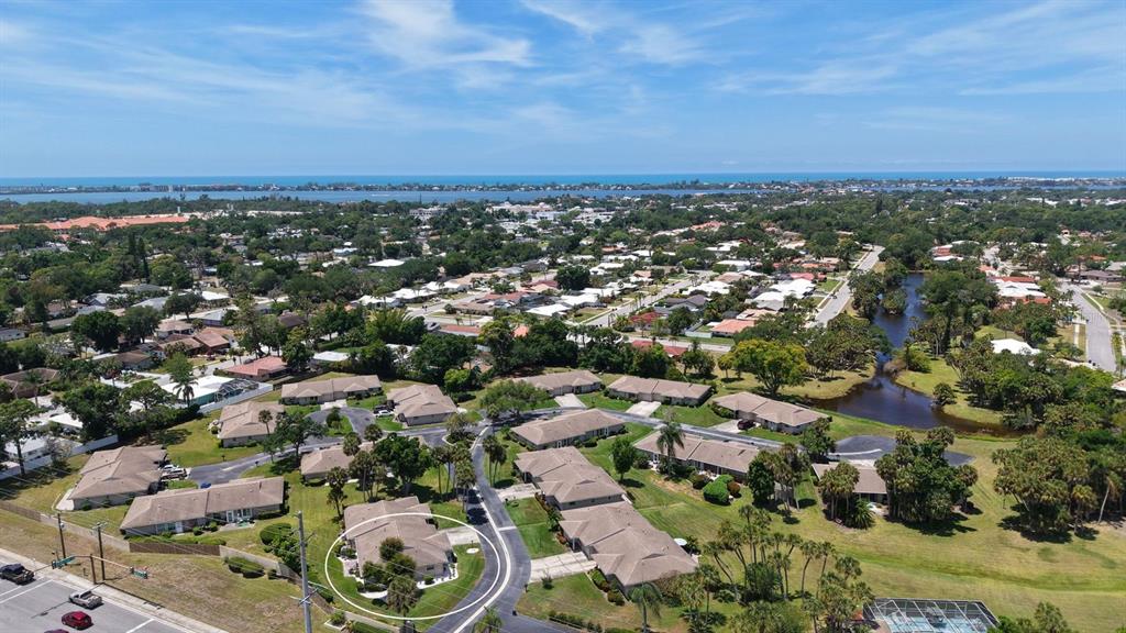 An aerial view shows a residential community with a circled single-story building and nearby pond — 2902 CAPTIVA GARDENS DRIVE UNIT 3, SARASOTA, FL